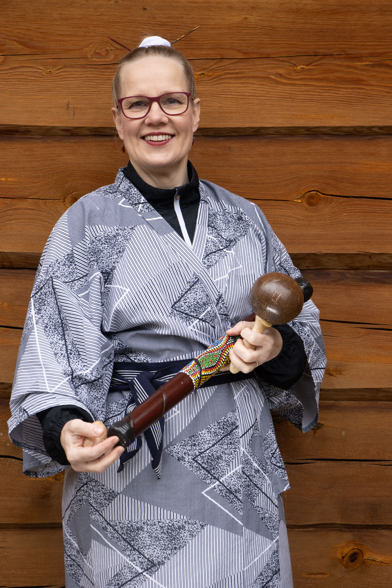 Seija Ekholm kädessään sadekeppi ja marakassi.